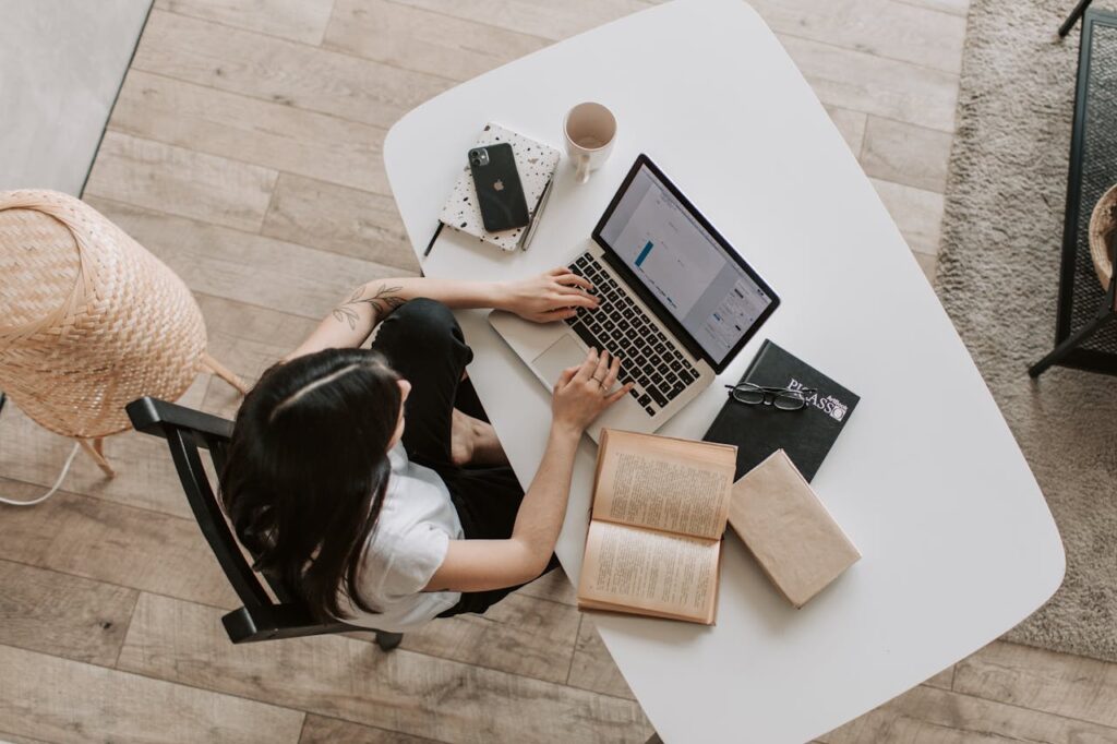 Young lady typing on keyboard of laptop in living room